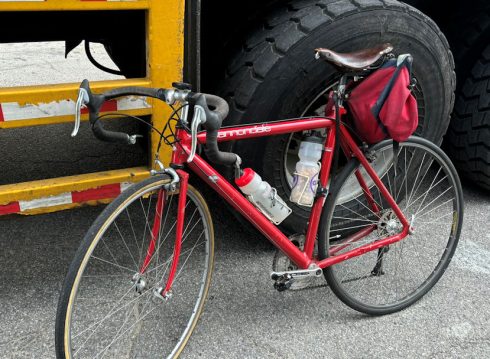 Bicycle with handlebar end hooked on truck side guard