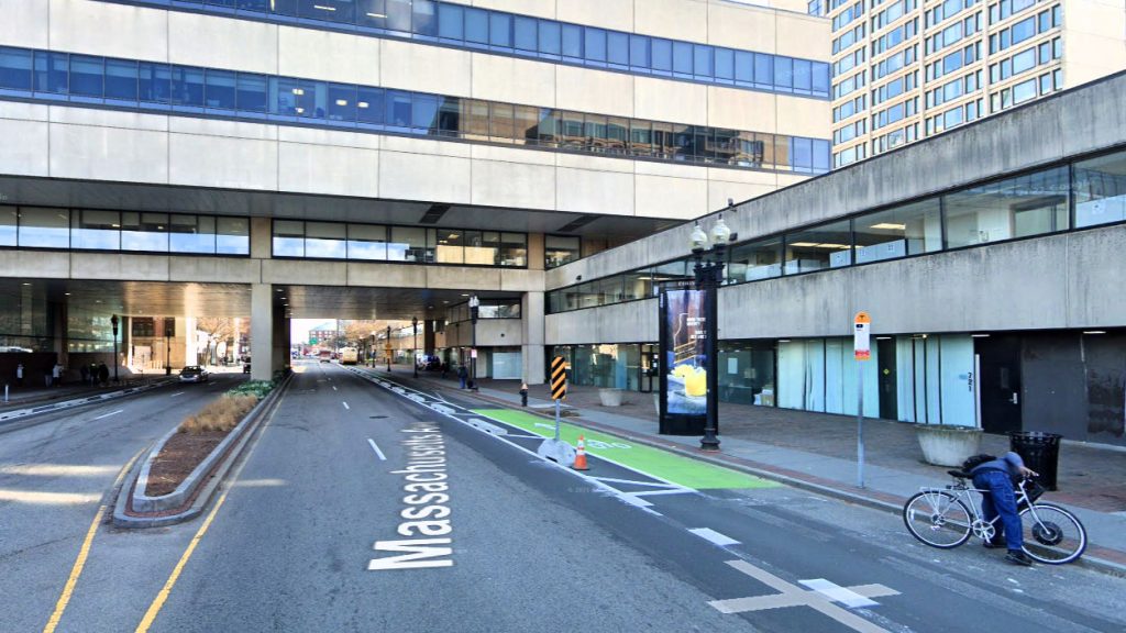 Concrete barriers and a bicyclist mounting the sidewalk.