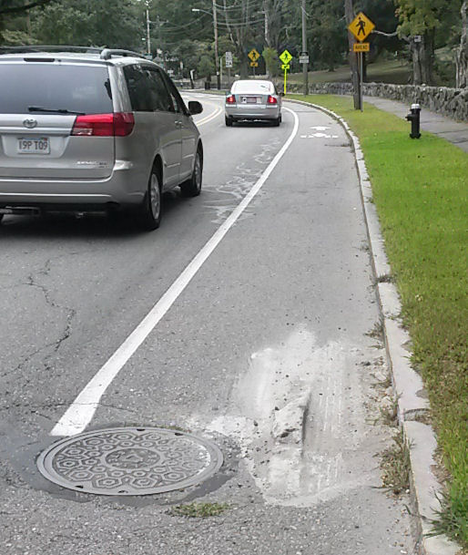 Pile of hardened concrete in the bike lane on massachusetts Avenue south of Season's Four driveway