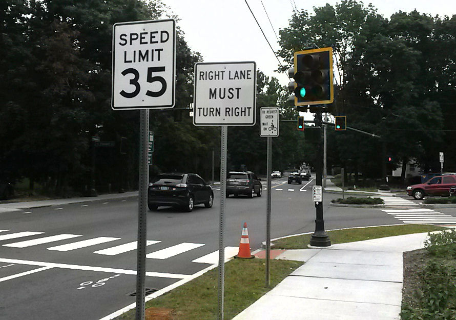 sidewalk. Placing one sign to hide another is contrary to standards.